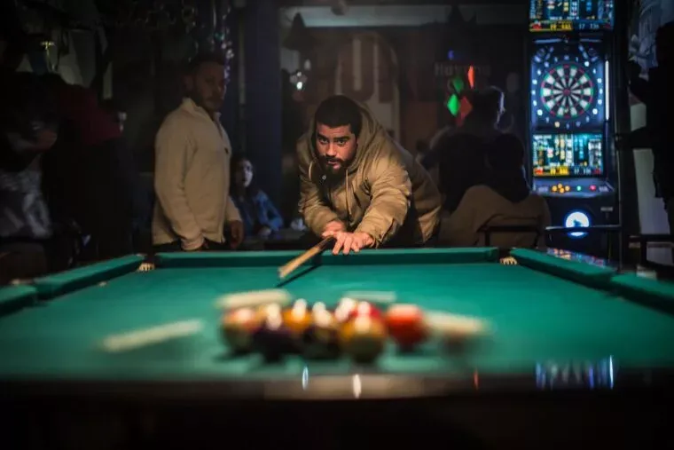 man in brown jacket playing billiard