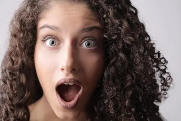Close-up Photo of Shocked Woman With Brown Curly Hair